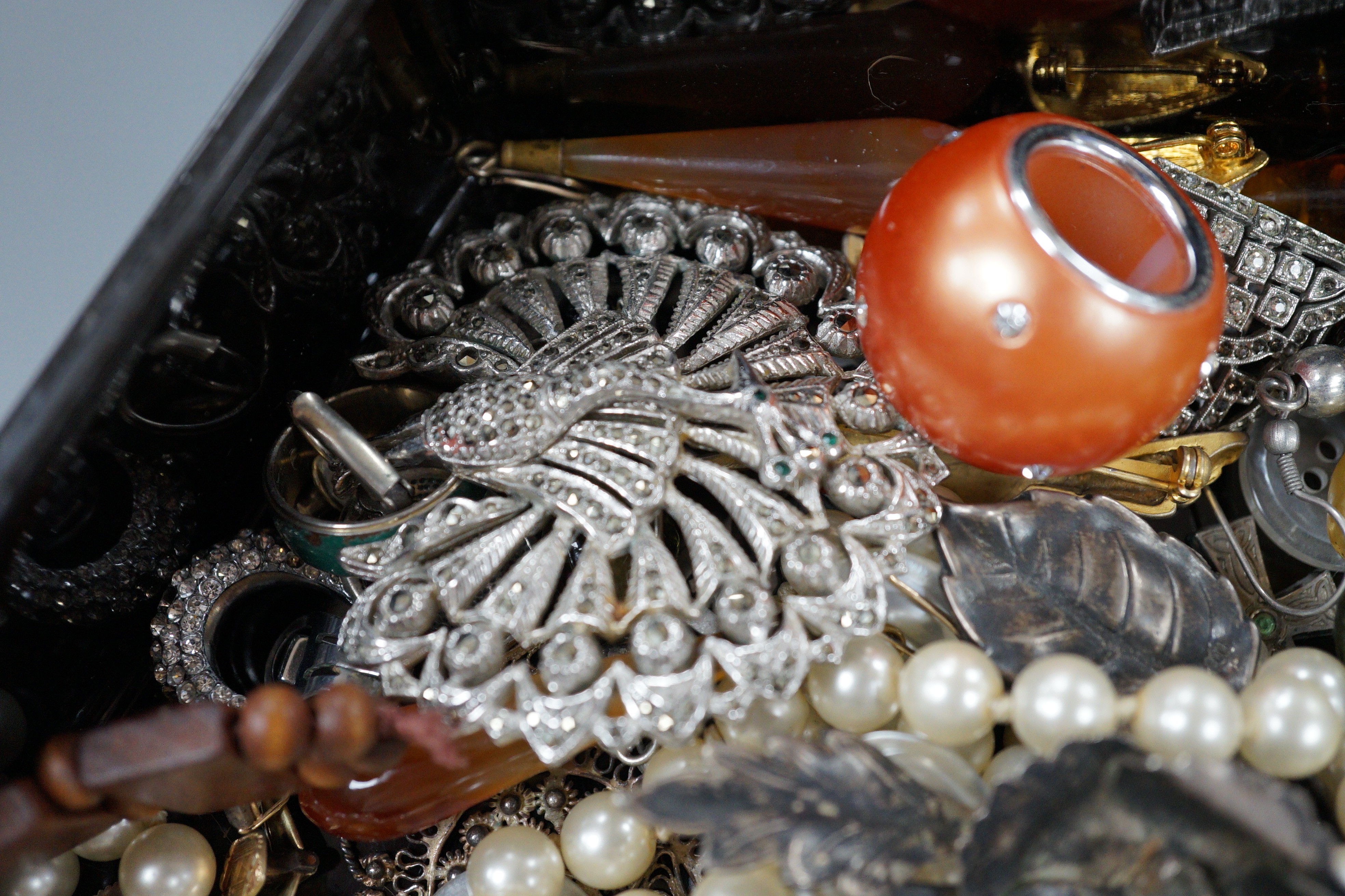 A quantity of assorted costume jewellery in a lacquer box.